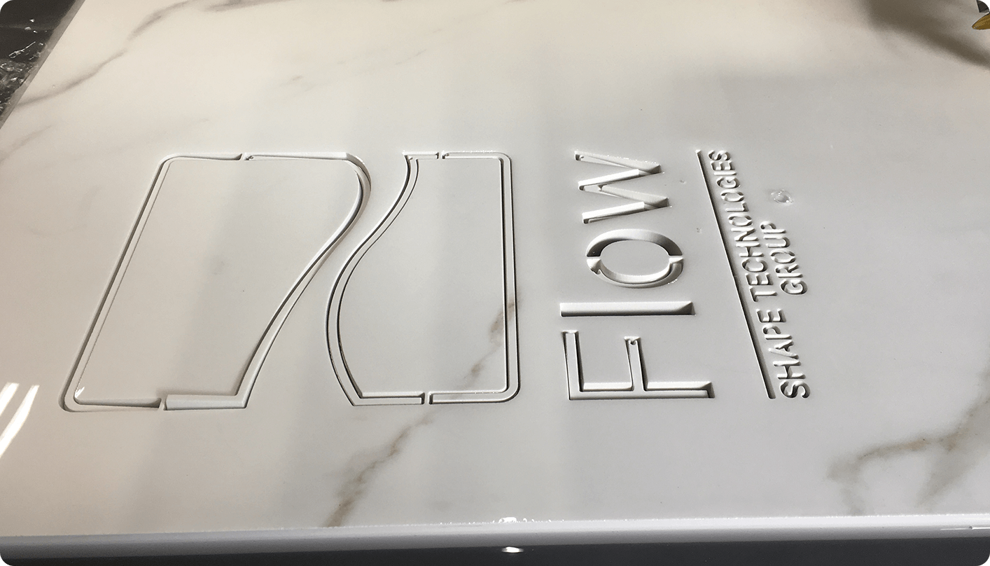 The Flow logo cut out of marble using a waterjet